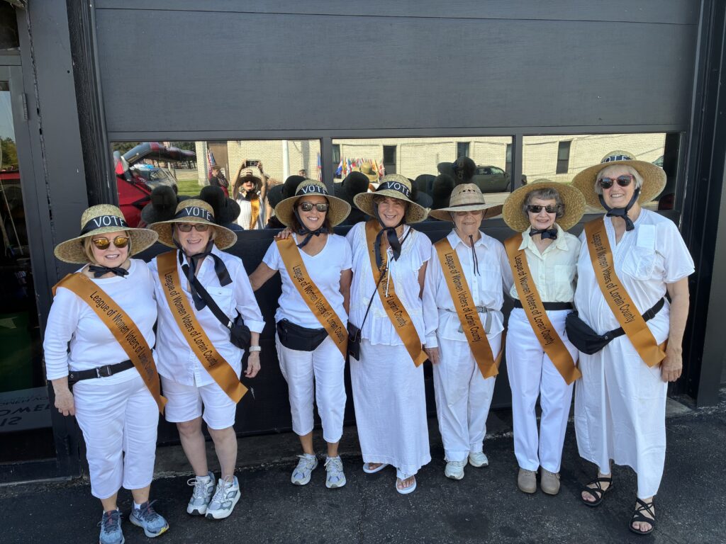 IMG_0344 A group of League members, wering white with sashes and straw hats that say, "vote."